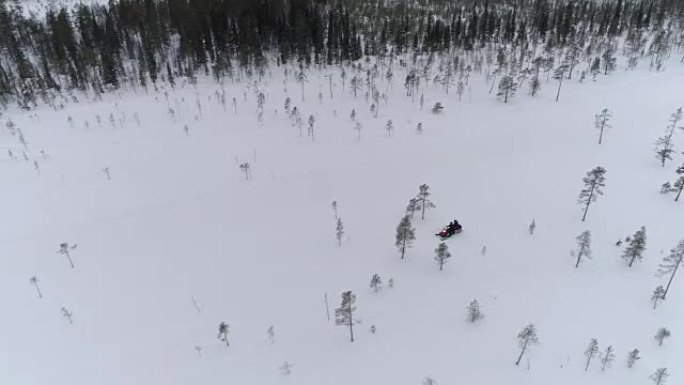 特写无法辨认的夫妇在白雪皑皑的冬季山坡上驾驶雪地摩托