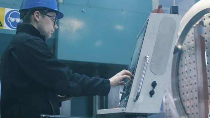 工厂工人正在用平板电脑编程一台数控铣床。