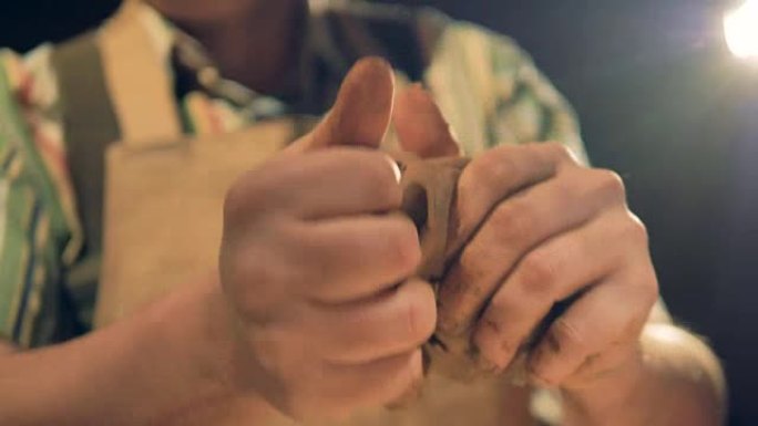 陶艺家手指压入粘土揉捏时的视野很低。