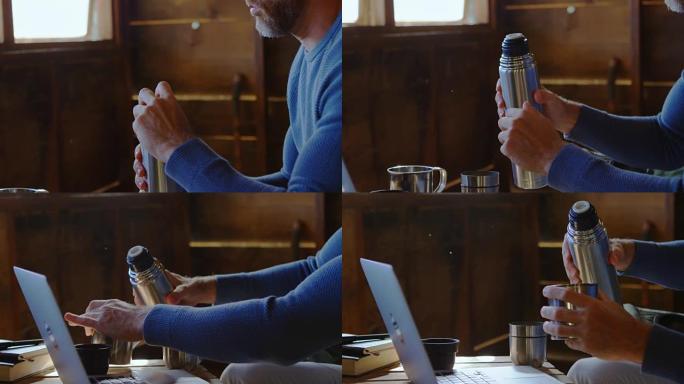 男子在家里用笔记本电脑时喝咖啡4k