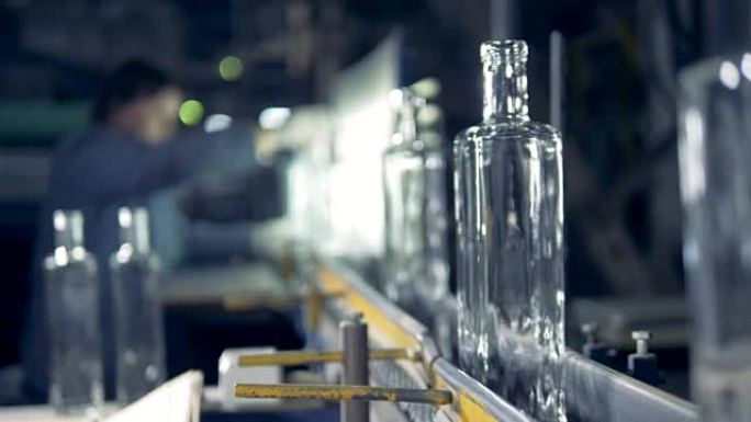 透明瓶子正在后台由工厂工人检查和调整