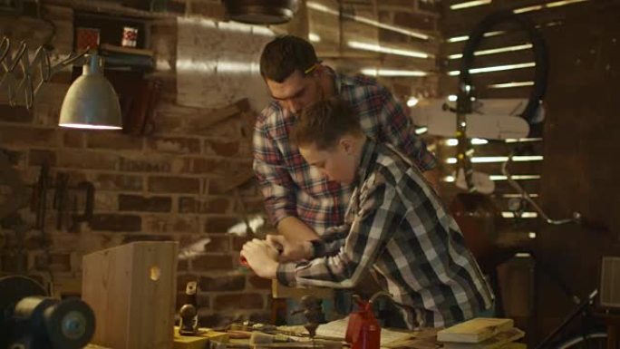 父亲和儿子在家里的车库里木工。