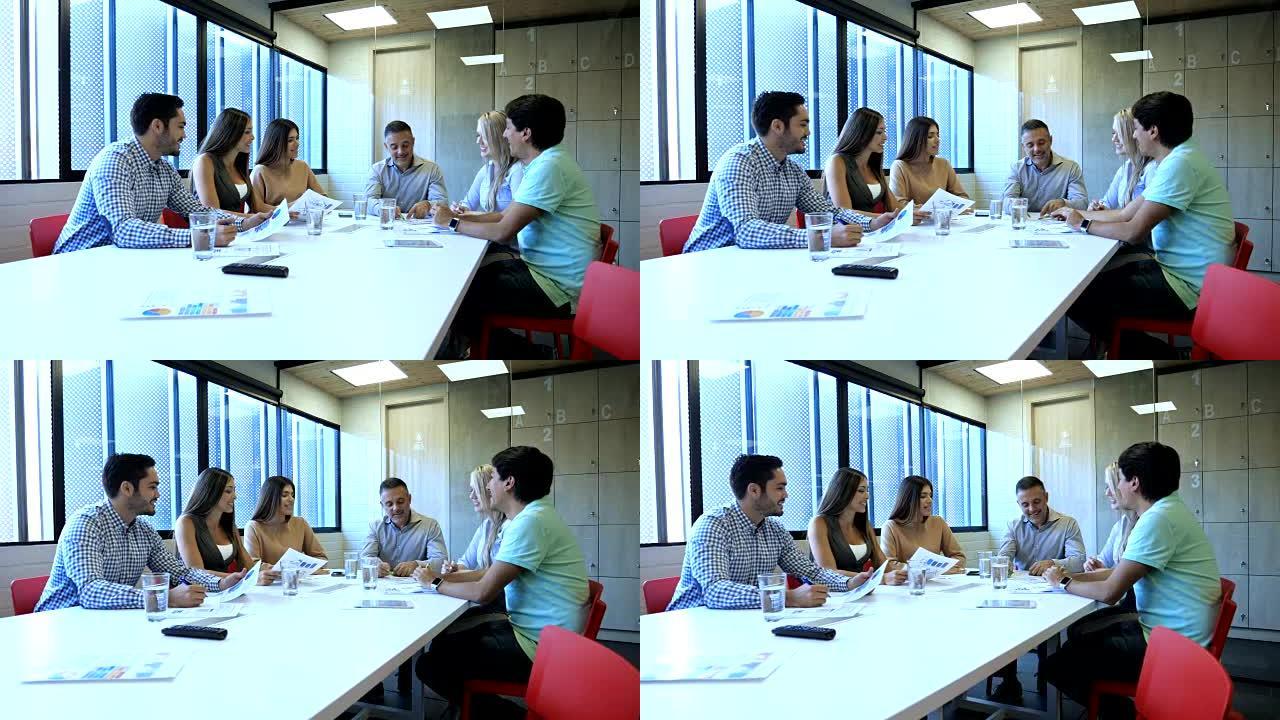 拉丁美洲成年人在会议室的商务会议上检查了一些文件，每个人看起来都很高兴