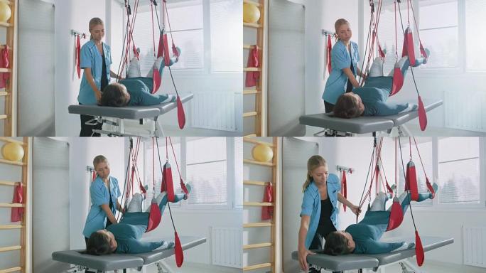 物理治疗师协助女性创伤患者，在特殊的悬吊绳系统上进行康复理疗。缓解背痛。现代诊所使用最先进的康复程序