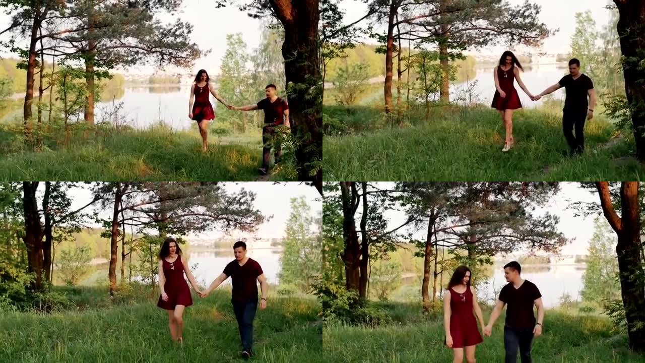 幸福的夫妇走在河岸上，牵着手。夏季的森林。美丽的自然观。慢镜头，稳定镜头