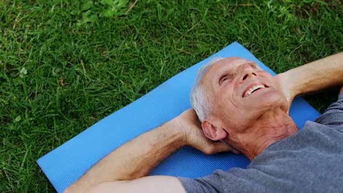 老人躺在4k花园的运动垫上
