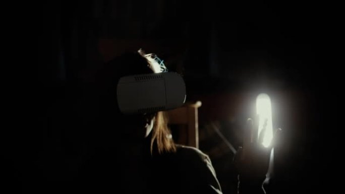 在聚光灯下使用VR头盔的女人
