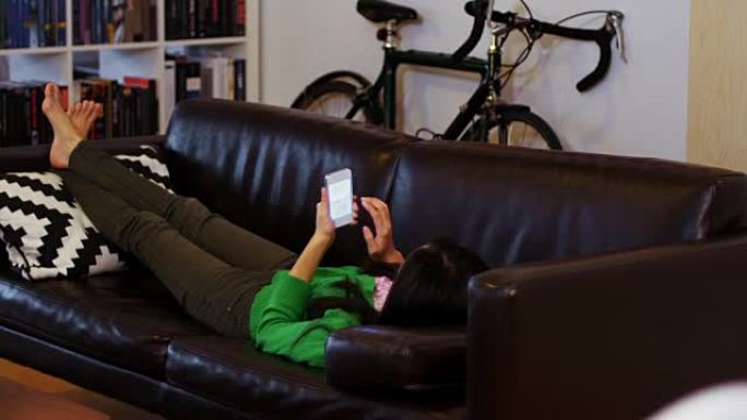 女人在客厅用手机在沙发上放松