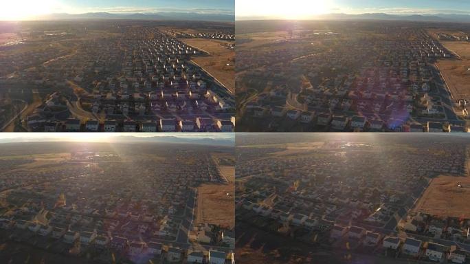 空中: 日出时被群山环绕的山谷郊区城镇的排屋