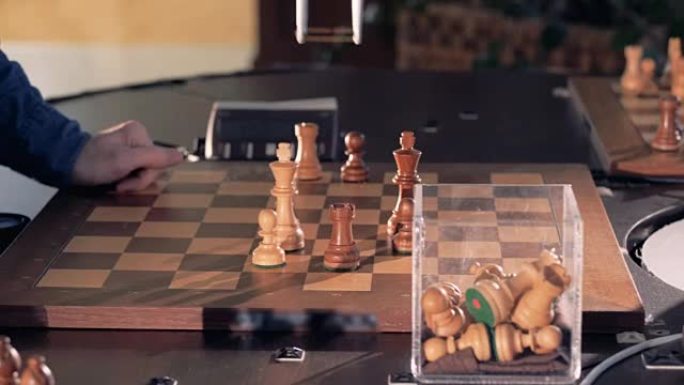 机器人和一个男人下棋。手机械手移动国际象棋并按下控制表的键。4K。