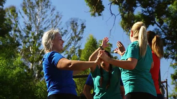 一群健康的女性在障碍赛中互相击掌