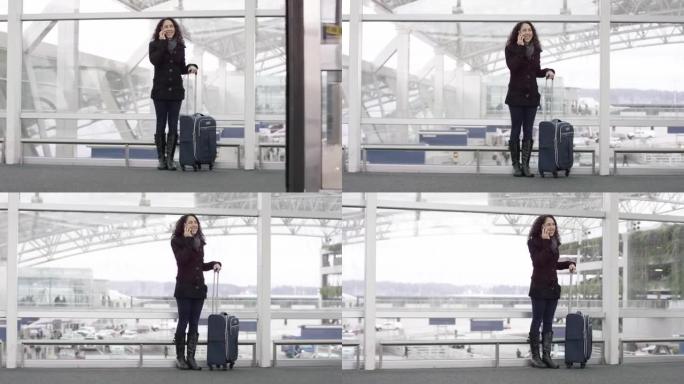 一名年轻的民族妇女在机场用手机说话的镜头