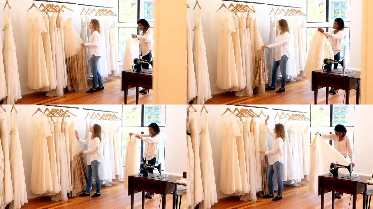 女性时装设计师在衣杆上布置连衣裙