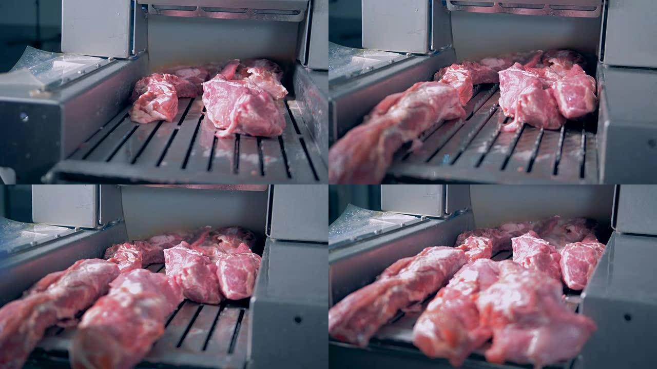 一个工人把肉放在研磨机上。