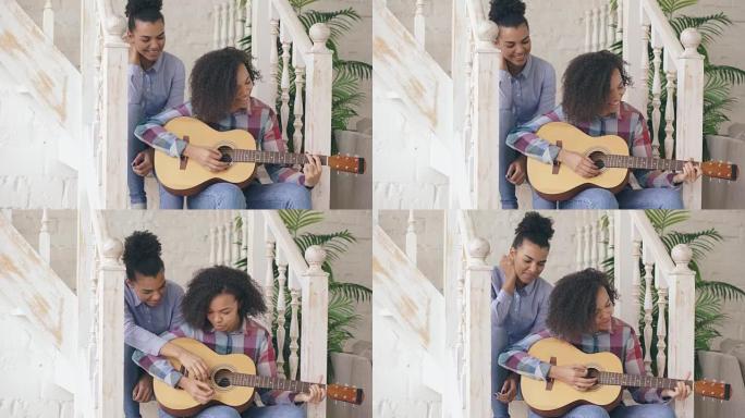 两个巴西卷发女孩姐妹坐在楼梯上练习弹吉他。朋友在家里玩得开心，唱歌