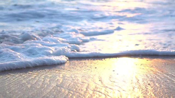慢动作宏观: 蓝海起泡，滑动和洗涤惊人的沙滩