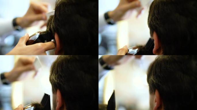 理发师的慢动作用电动剃须刀剪掉顾客的头发