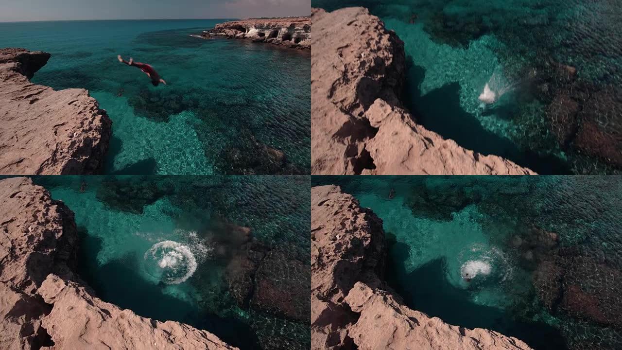 年轻的悬崖潜水员翻筋斗从岩石上跳入大海