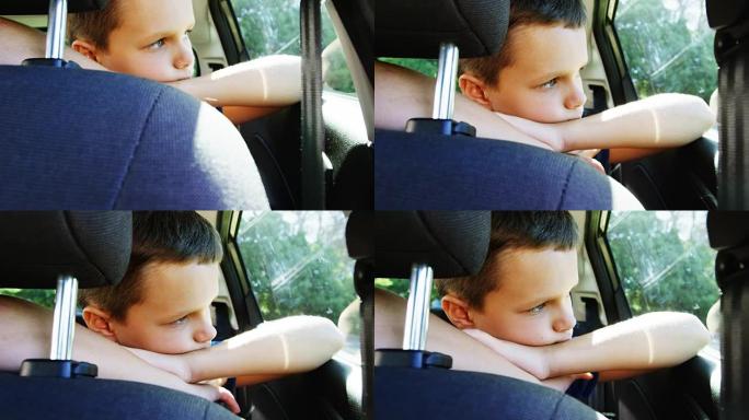 男孩在汽车后座上放松