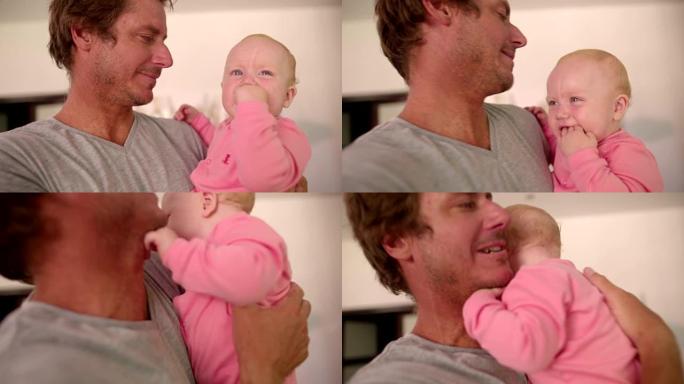 现代爸爸在室内抱着婴儿女儿微笑