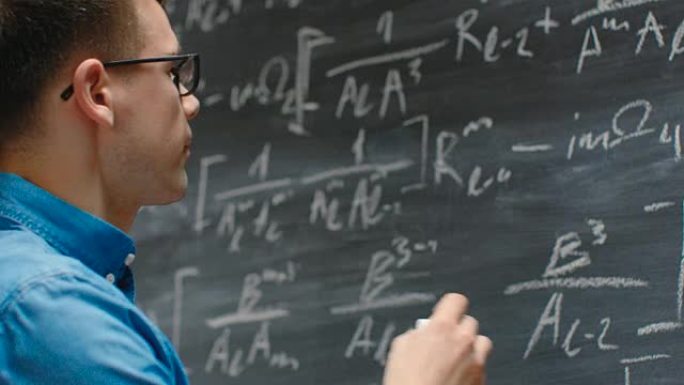 才华横溢的年轻数学家在黑板上写下又长又复杂的数学方程/公式。