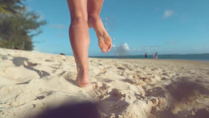 特写: 无法辨认的女人在海滩上慢跑时，沙粒在空中飞舞