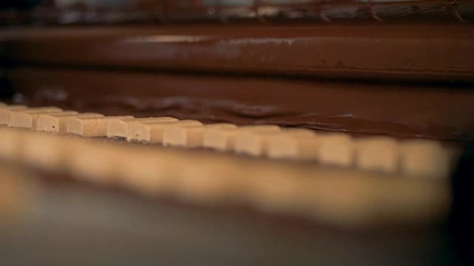 糖果，牛轧糖在糖果生产输送机上倒入巧克力。