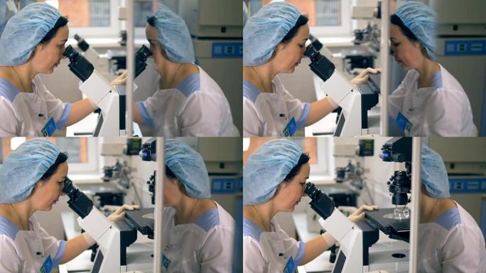 一名医疗技术人员看着显微镜的镜像脸照片。