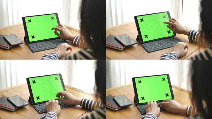 使用带有绿色屏幕的数字平板电脑的年轻女子