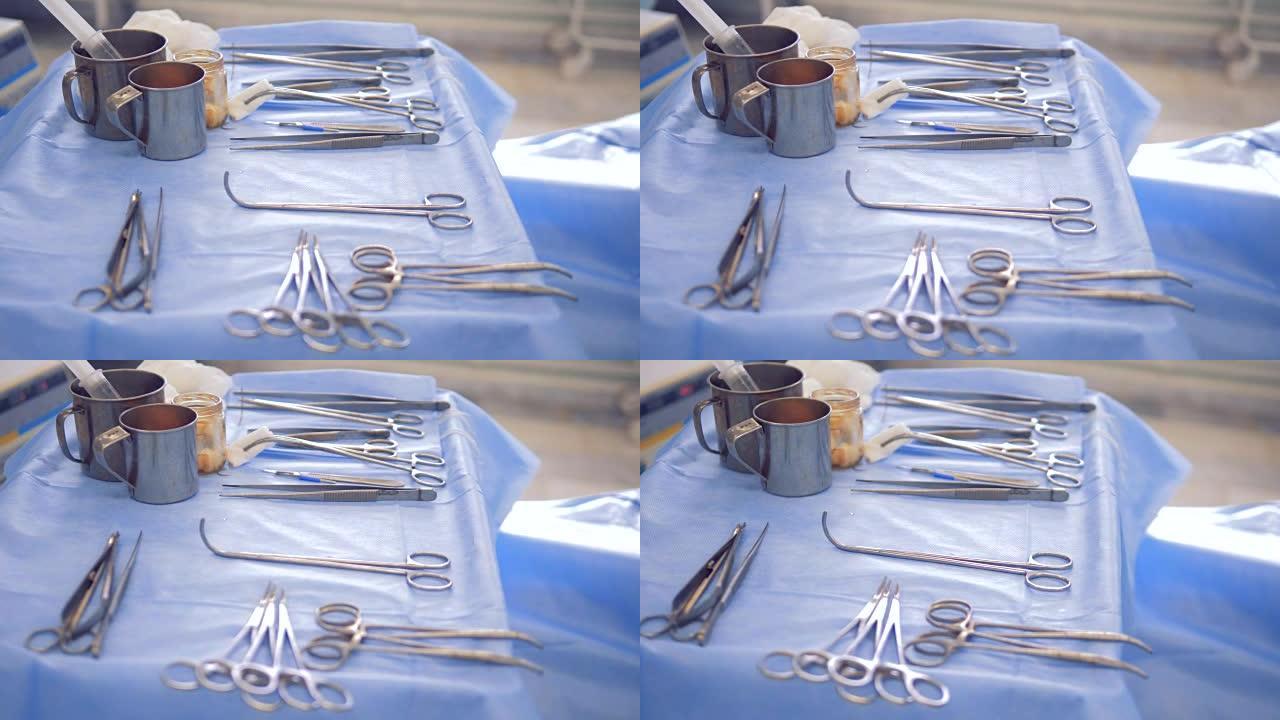 手术器械躺在医院的桌子上，桌子上覆盖着保护材料