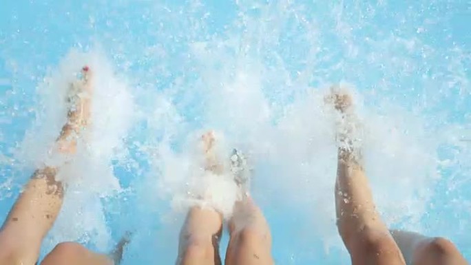 慢动作特写: 三个长腿女孩在炎热的夏天泼水