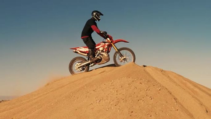 职业摩托车越野赛摩托车骑手在沙丘和越野车道上行驶的远景。