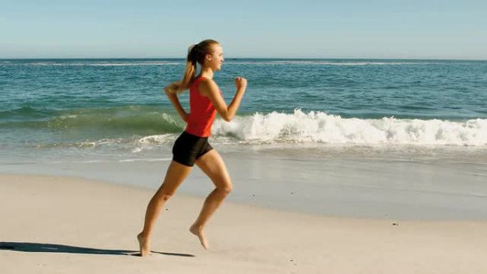 穿着红色背心的女人在海滩上奔跑