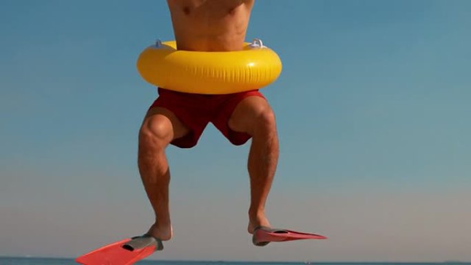 男子在海滩上戴着脚蹼和橡胶圈