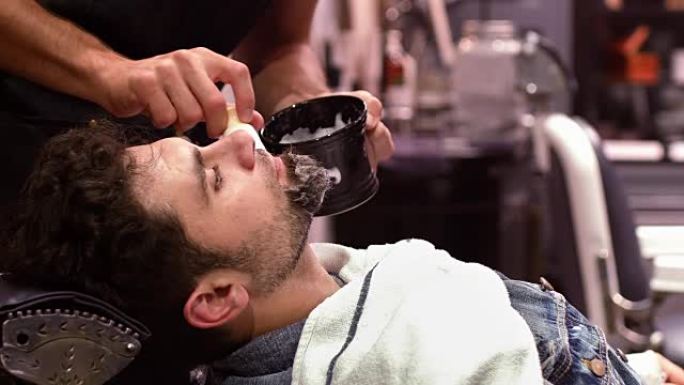 男人在理发店用剃须刷剃掉胡须