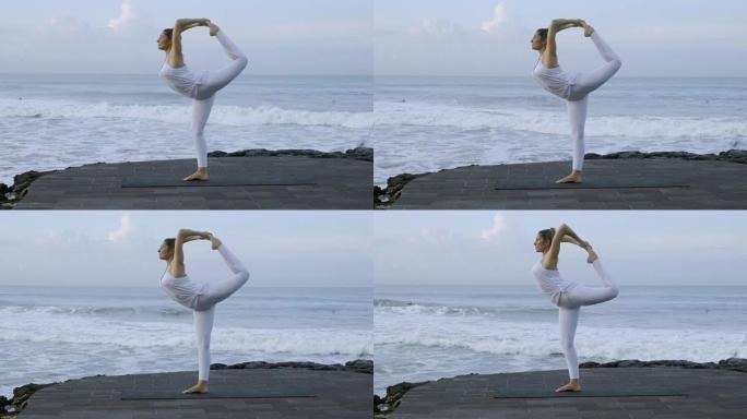 在海滩上做舞者瑜伽姿势的女人
