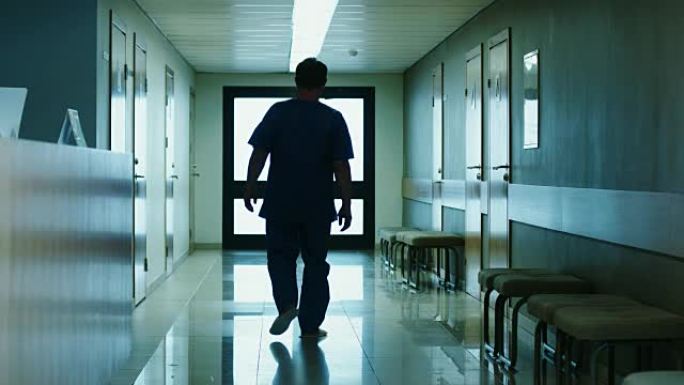 在医院里，老人在接待处问问题，然后沿着走廊走。清洁现代医疗设施。
