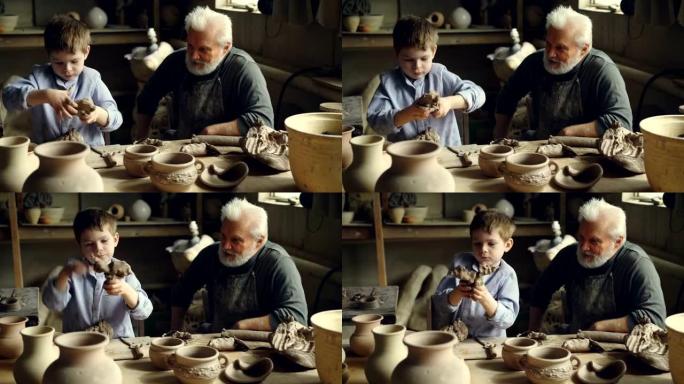 Child正在学习与黏土一起工作，并在与祖父呆在陶器车间的同时享受揉捏的乐趣。家庭传统和陶瓷概念。