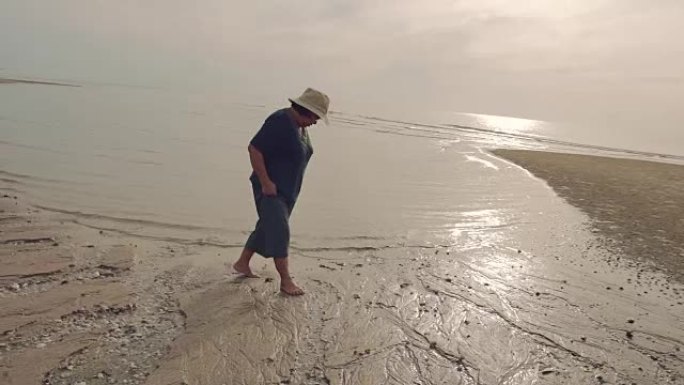 祖母在假期在海滩上散步