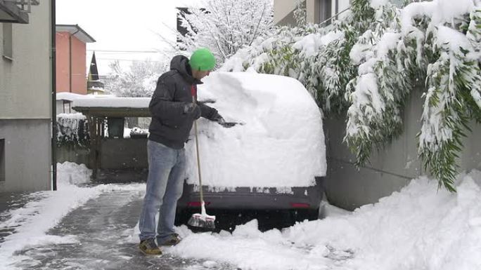 男子清理汽车上的积雪