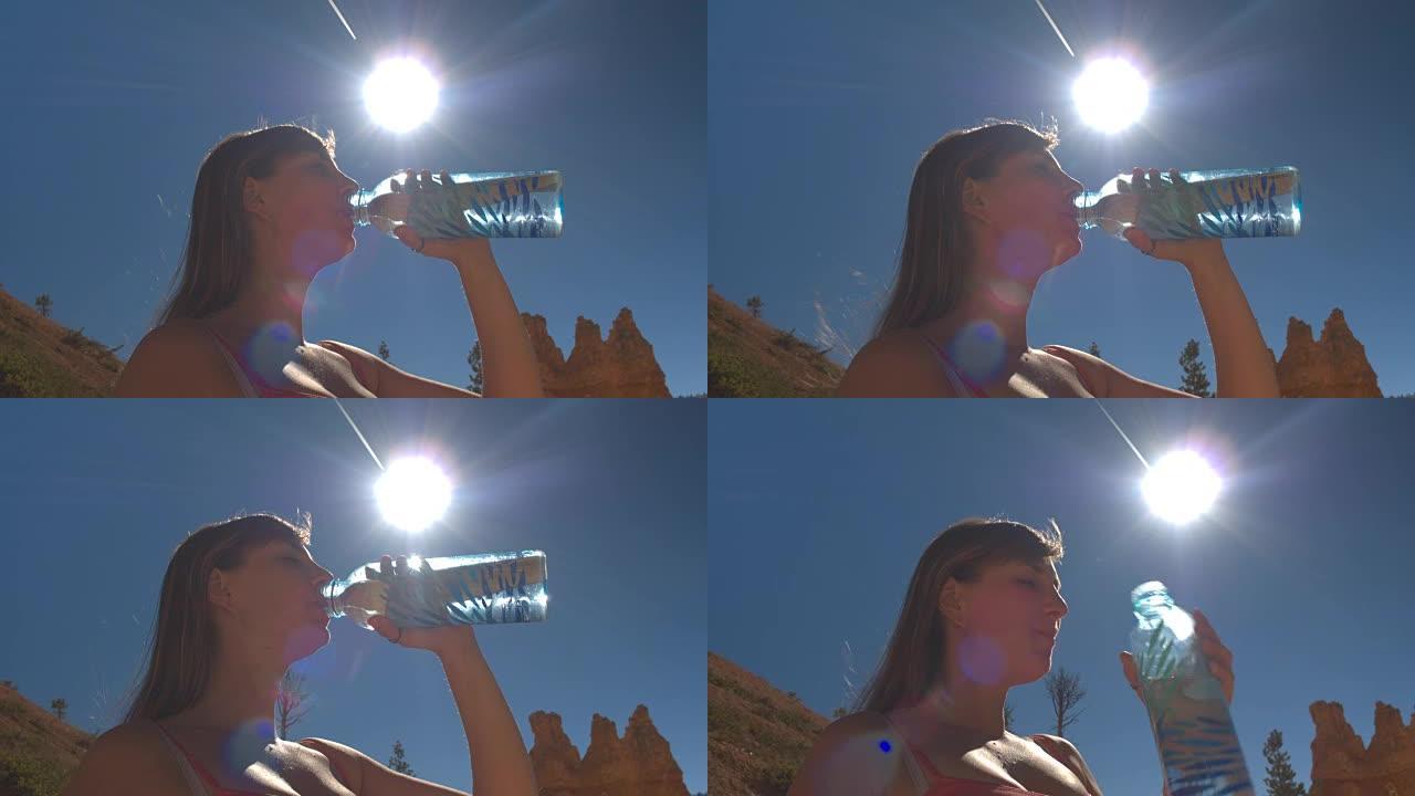 特写: 年轻女子旅行者喝水，在炎热的阳光明媚的沙漠中补水