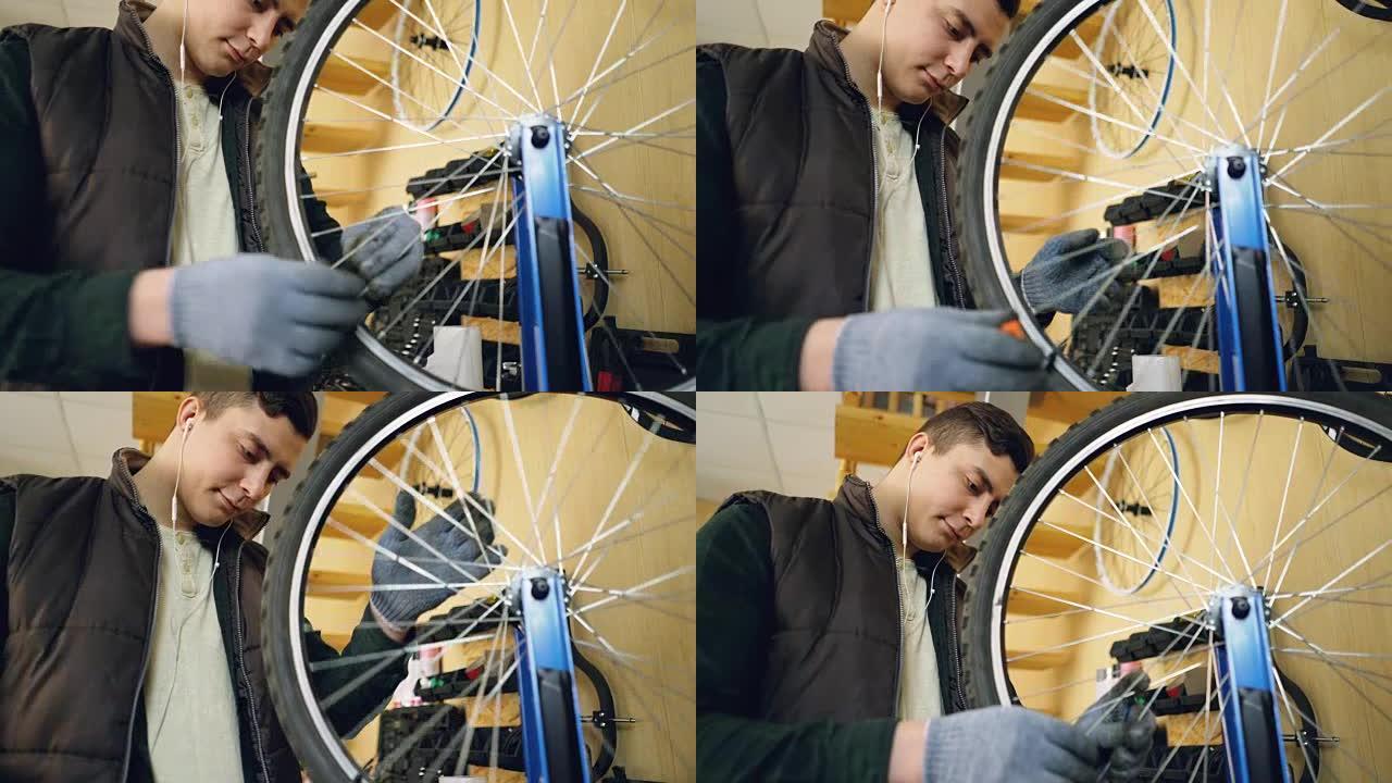专业修理工正在固定自行车车轮辐条，用特殊工具和旋转轮来校直它们。职业和维修概念。