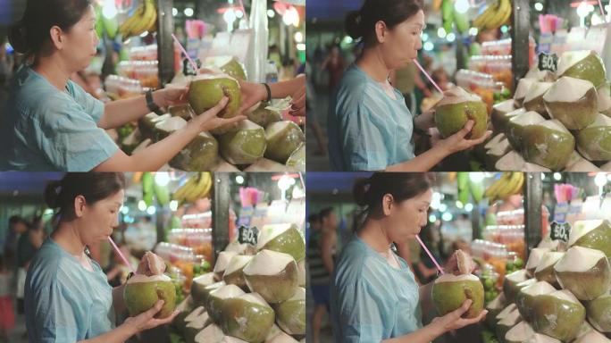妇女在泰国街头食品上购买椰子
