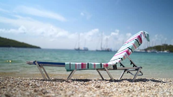 沙滩上有彩色毛巾的日光浴床