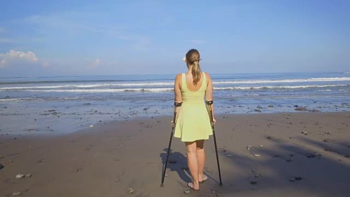 特写: 暑假在海滩上拐杖的坚强独立女人