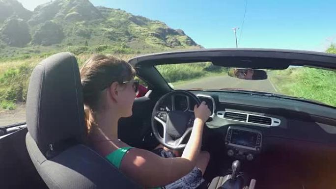 慢动作: 快乐的年轻女子在夏威夷阳光明媚的假期驾驶敞蓬车