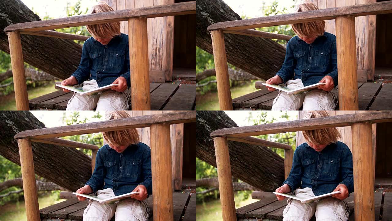 坐在树屋里读儿童读物的男孩