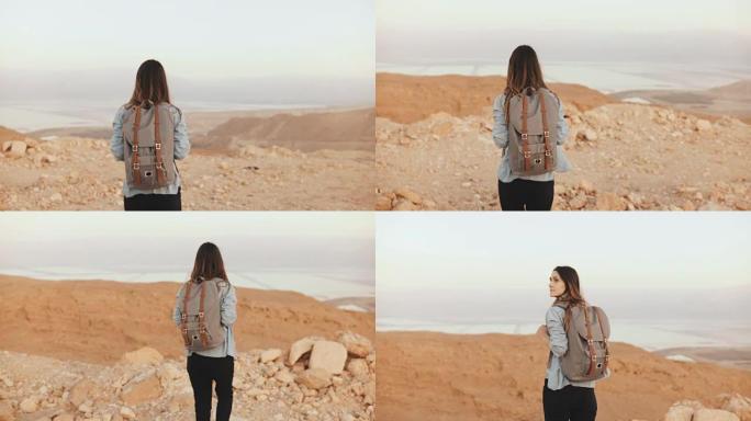 背着背包的女人在多云的沙漠里散步。年轻体贴的高加索女孩在干燥的沙滩上徘徊，微笑着。以色列4K