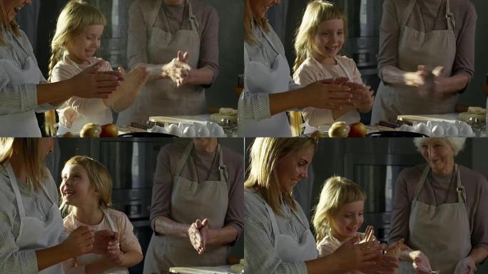 小女孩在做饭时与妈妈和奶奶拍手
