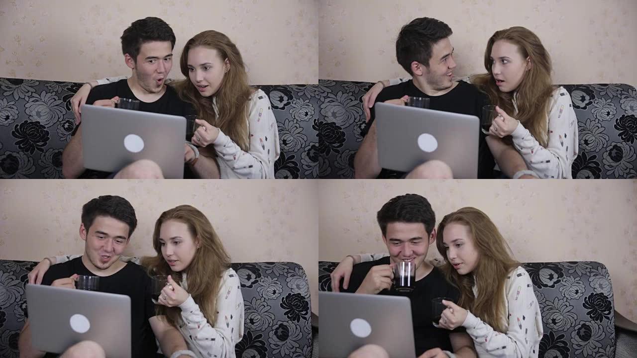 带着笔记本电脑的年轻快乐微笑夫妇